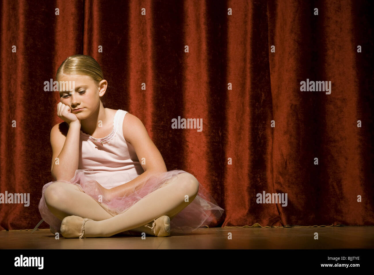 Ballerina girl sitting on stage sulking Stock Photo - Alamy
