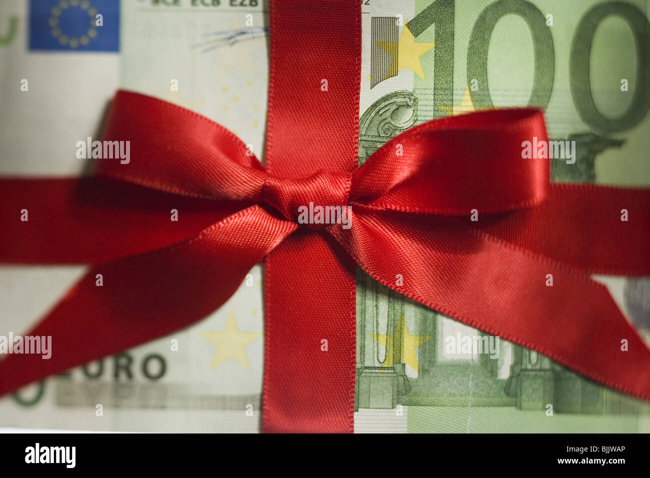 One hundred Euro banknote with red ribbon closeup Stock Photo - Alamy