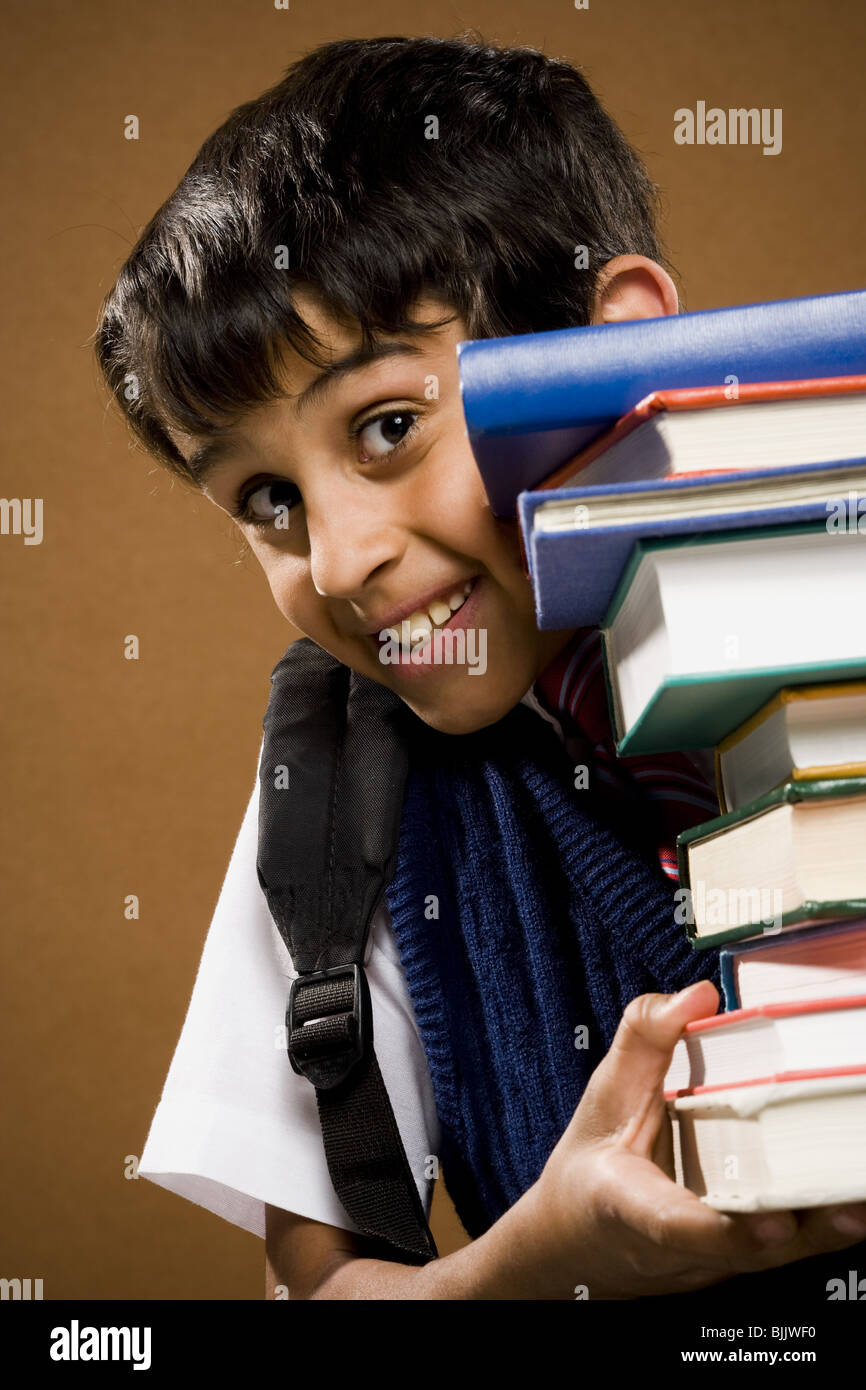 Boy holding pile of textbooks Stock Photo - Alamy