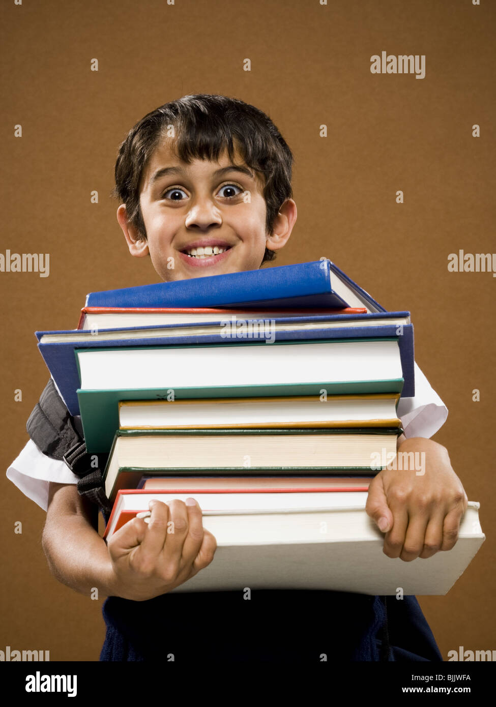 Boy holding pile of textbooks Stock Photo - Alamy