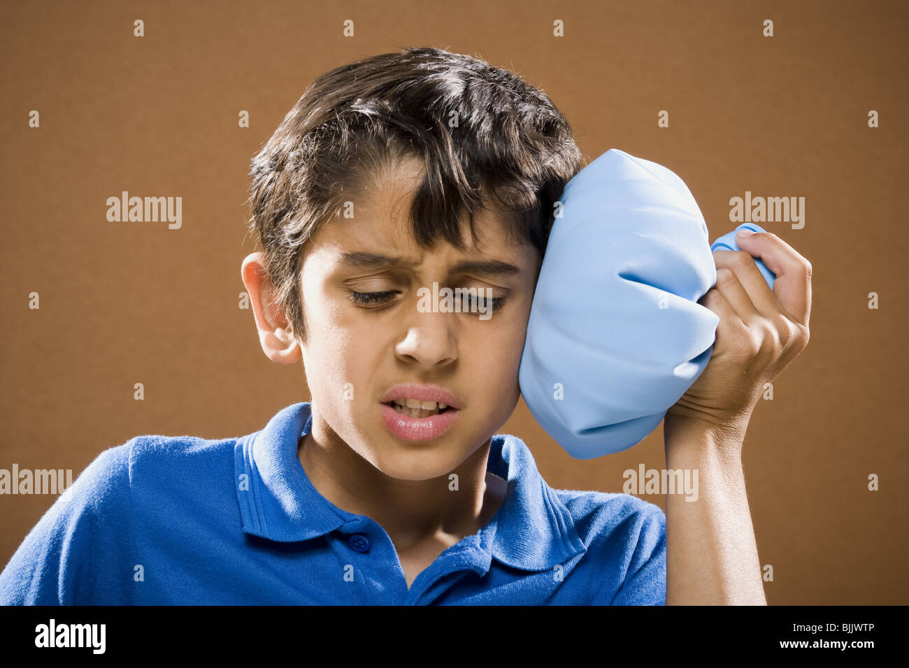 Boy holding ice pack to head Stock Photo