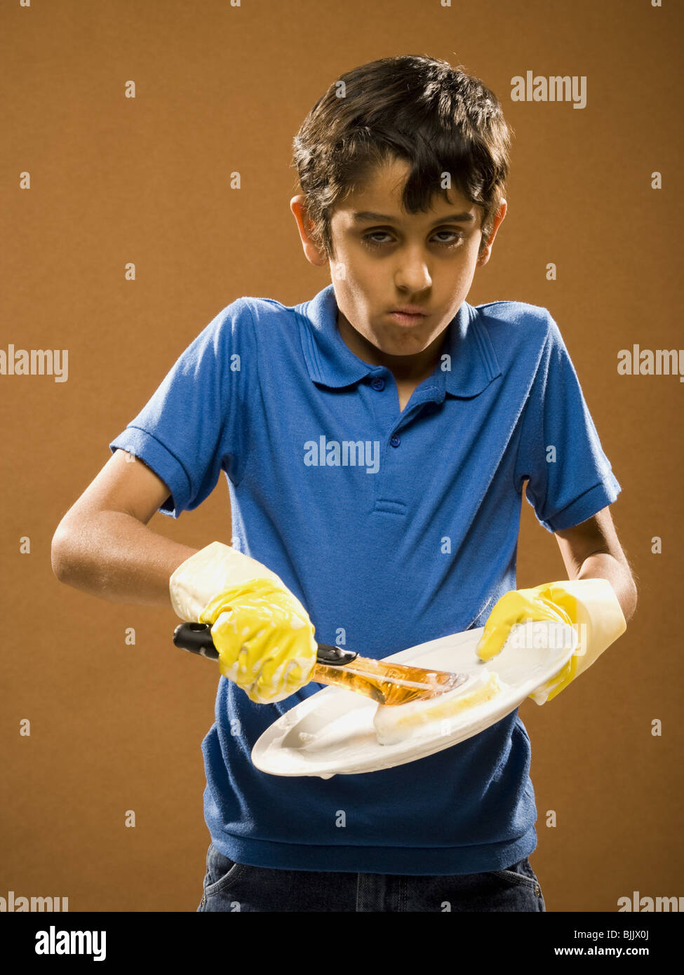 Boy with rubber gloves scrubbing plate Stock Photo Alamy