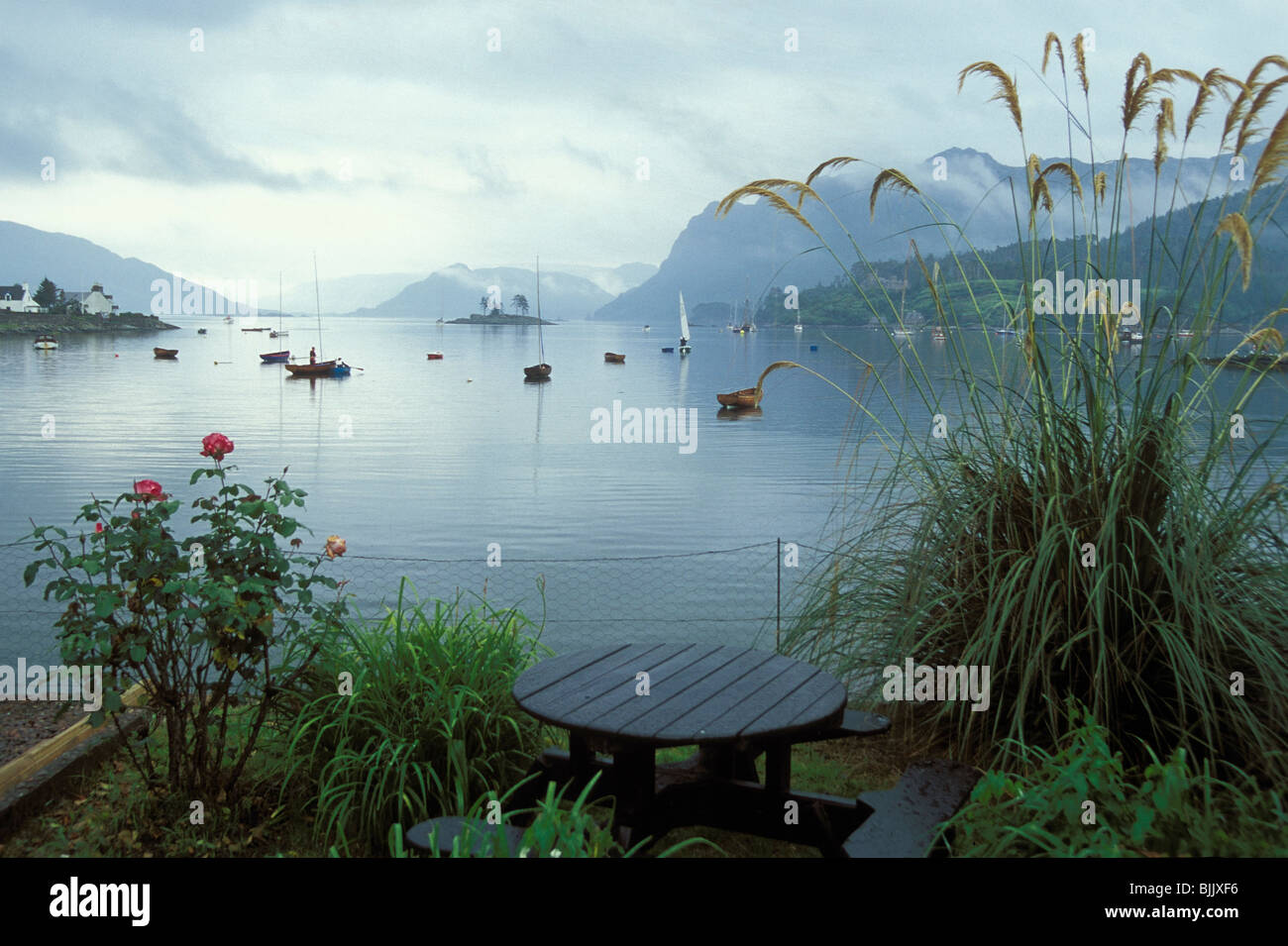 View from beer garden of Plockton Bay, Wester Ross on misty rainy day in summer, Stock Photo