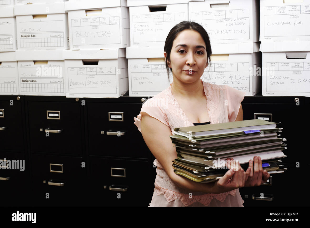 A woman filing documents into a hires stock photography and