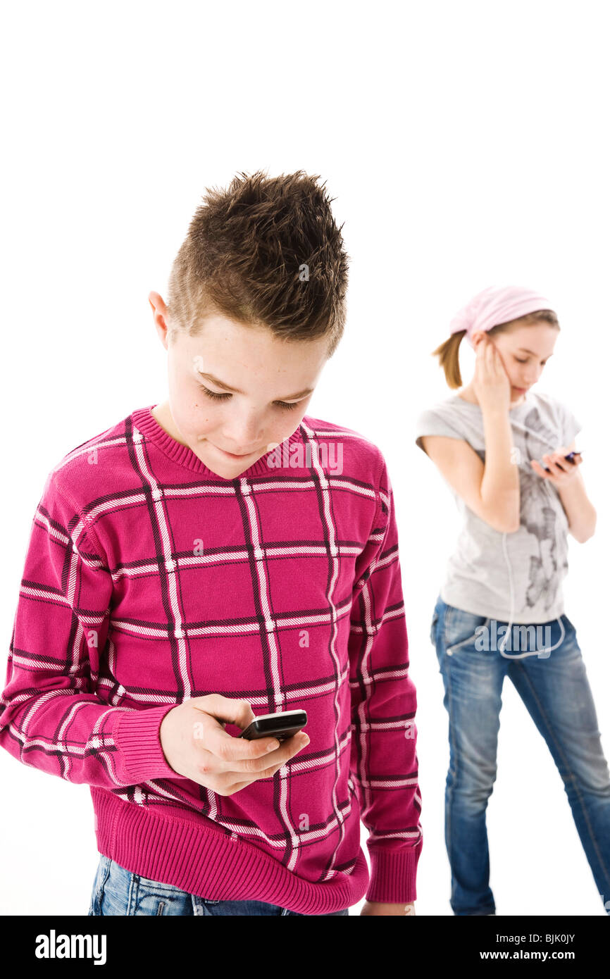Boy with a mobile phone and a girl with an iPod Stock Photo