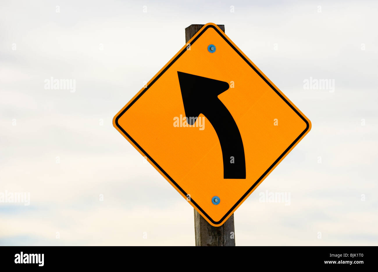 A highway sign warning of an approaching curve. Stock Photo