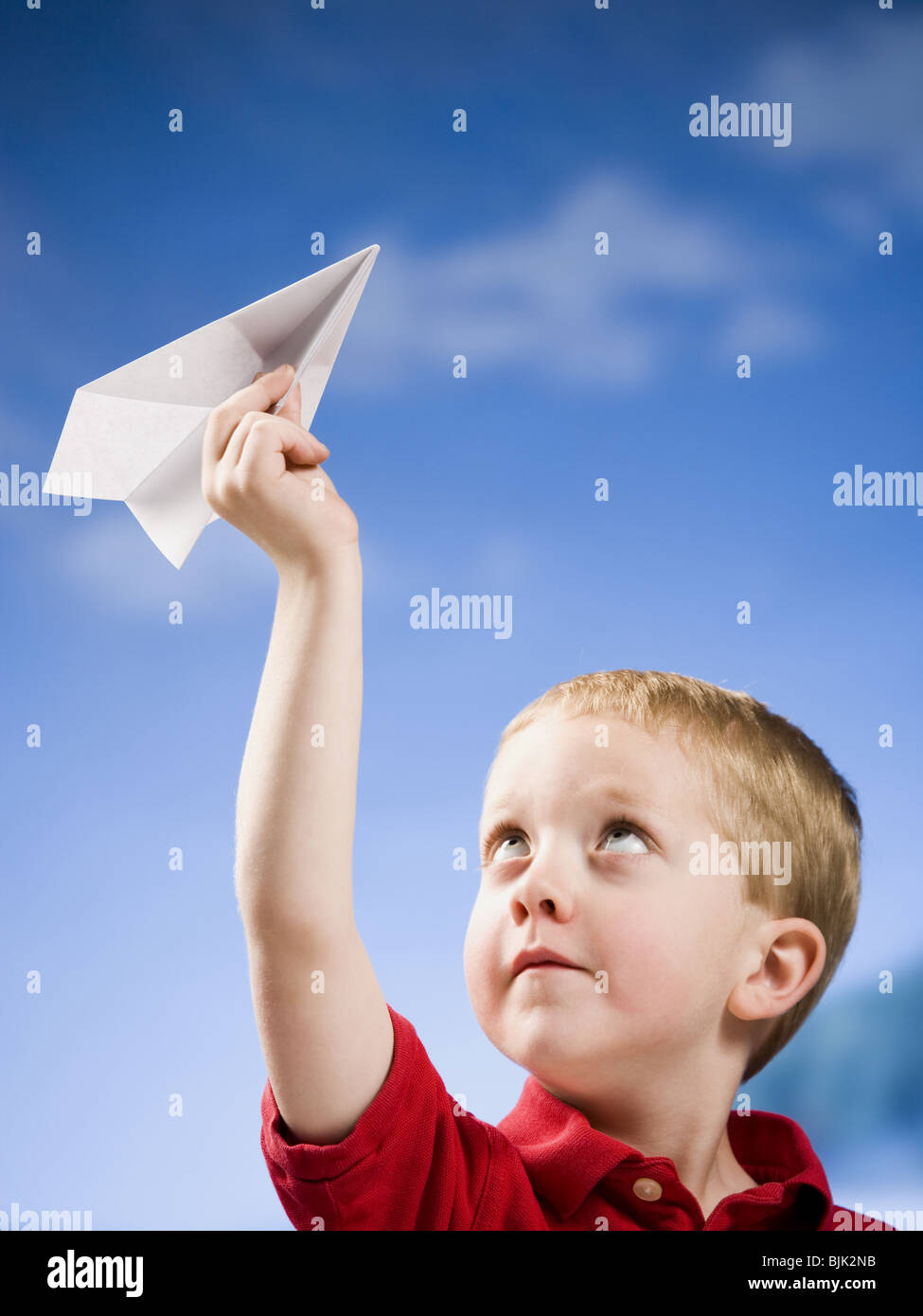 Boy with paper airplane outdoors Stock Photo
