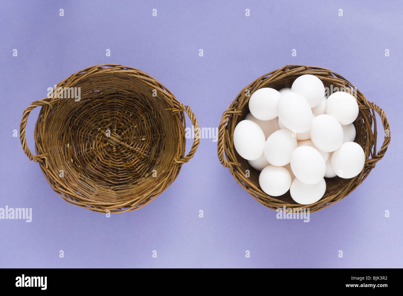Empty basket and basket filled with eggs Stock Photo
