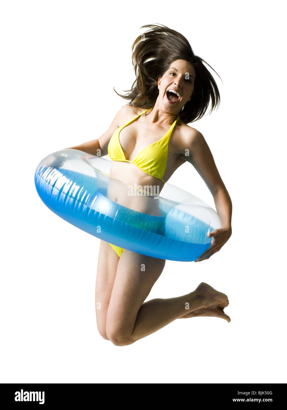 Woman in bikini with swimming ring around waist jumping and smiling Stock Photo