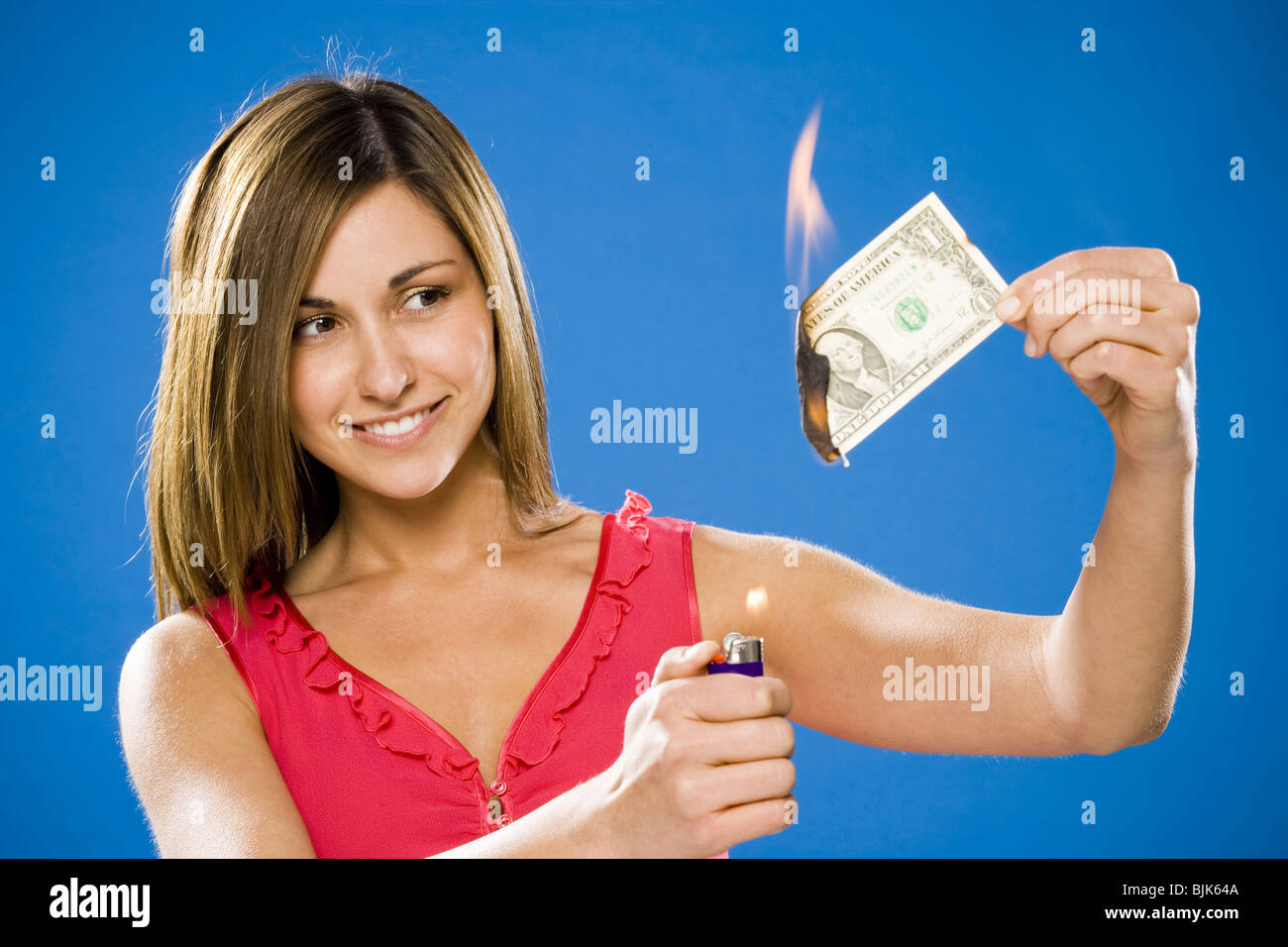 Woman setting American one dollar bill on fire Stock Photo