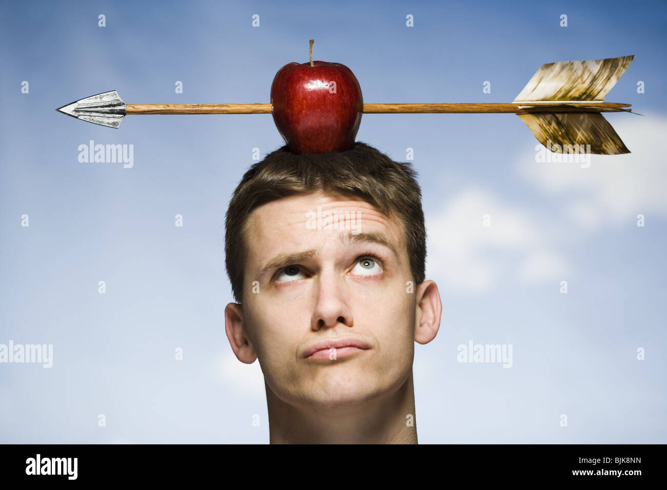 Man outdoors with arrow through red apple on head Stock Photo Alamy