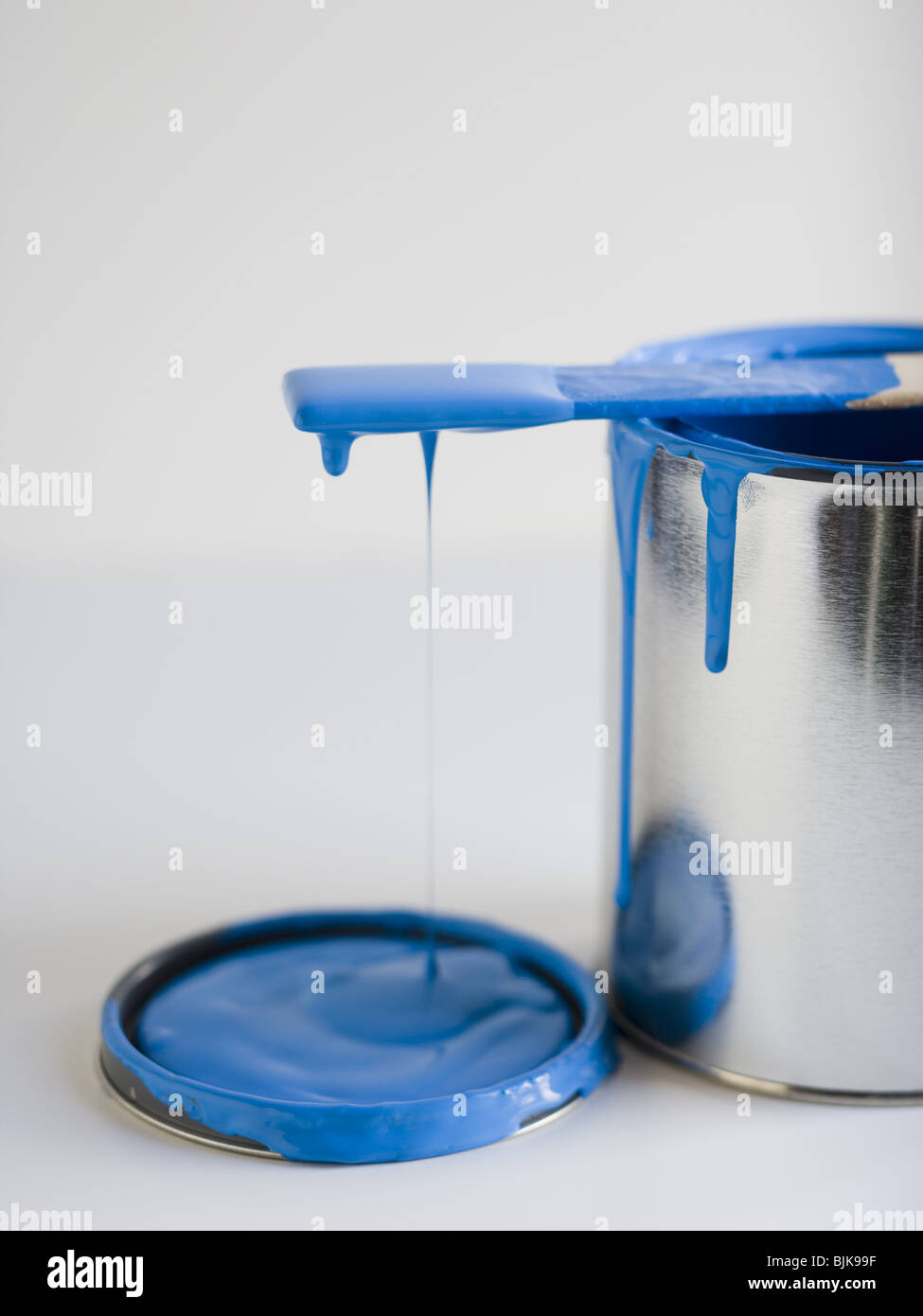 Dripping paint can with stir stick Stock Photo Alamy