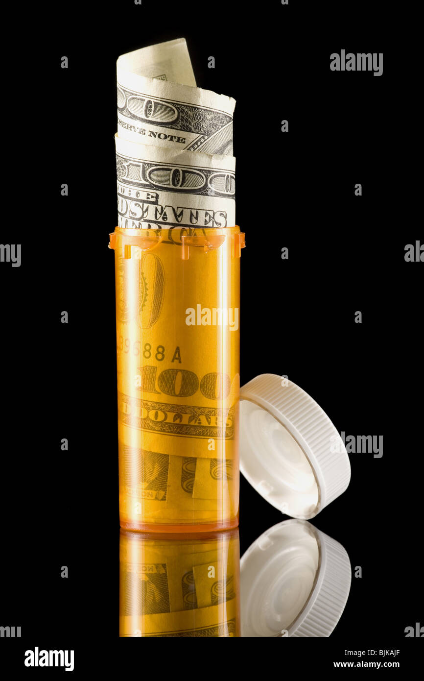 Prescription bottle with one hundred dollar bill inside Stock Photo