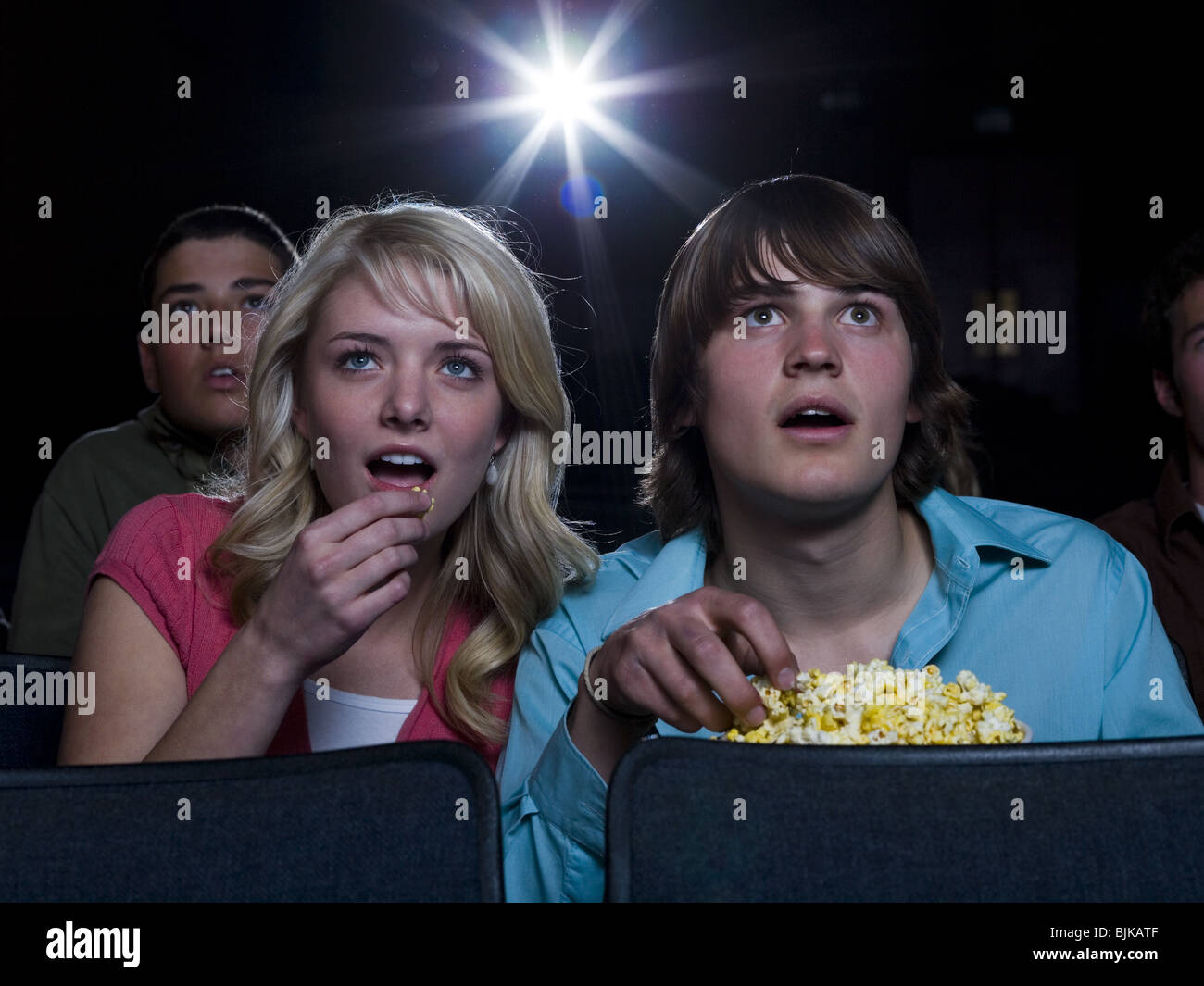 Boy and girl with popcorn frightened at movie theater Stock Photo Alamy