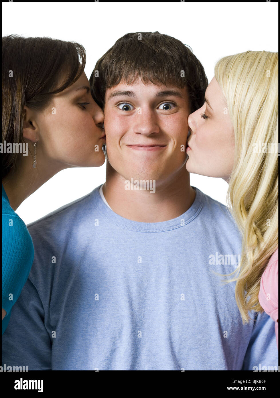 Boy being kissed on both cheeks by two girls Stock Photo