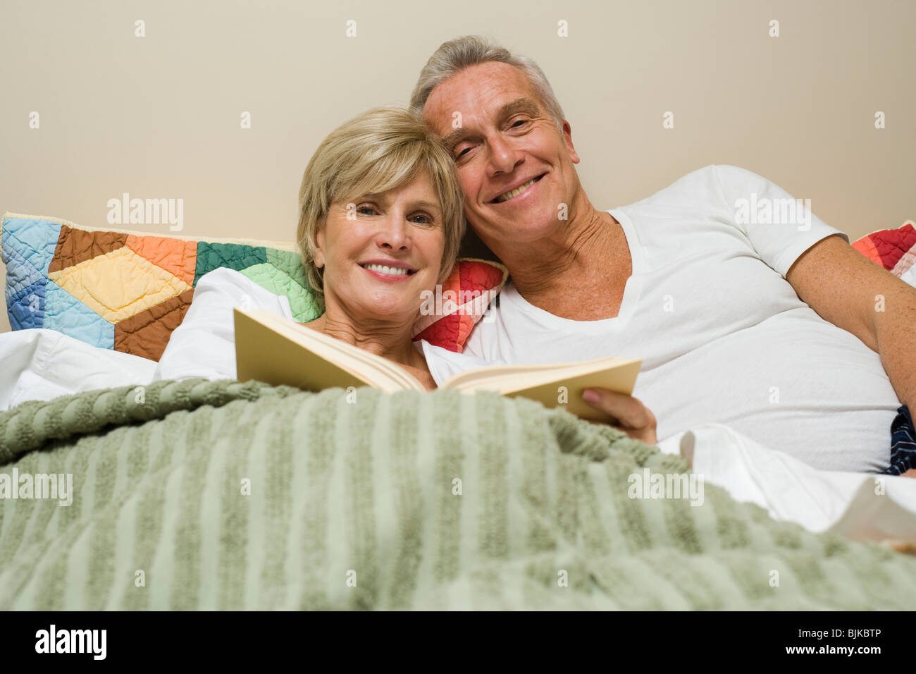 Mature couple in bed reading Stock Photo