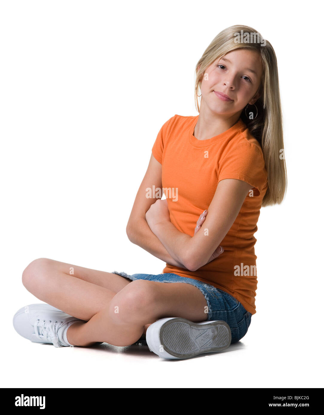Girl sitting with arms and legs crossed Stock Photo Alamy