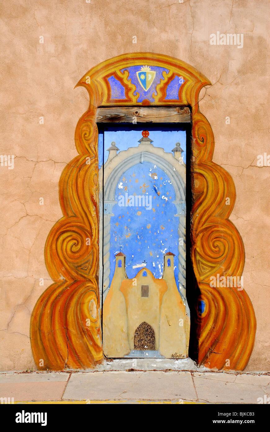 Santa Fe, New Mexico, USA - April 20, 2008: Artistically painted door and adobe wall with brilliant blue sky on sunny afternoon in downtown Santa Fe. Stock Photo