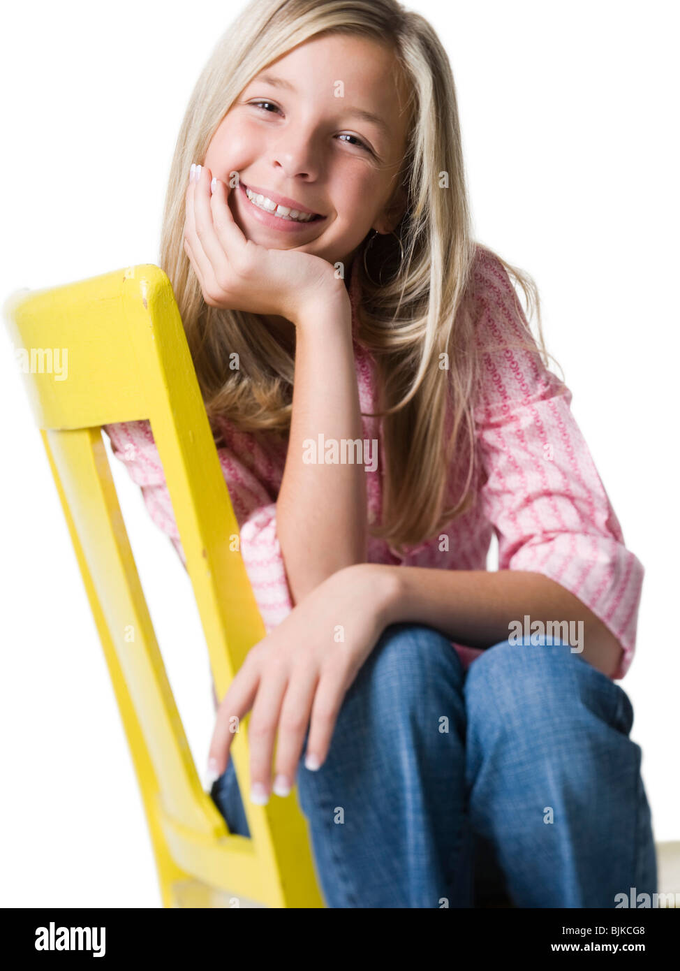 Girl sitting on yellow chair smiling Stock Photo - Alamy