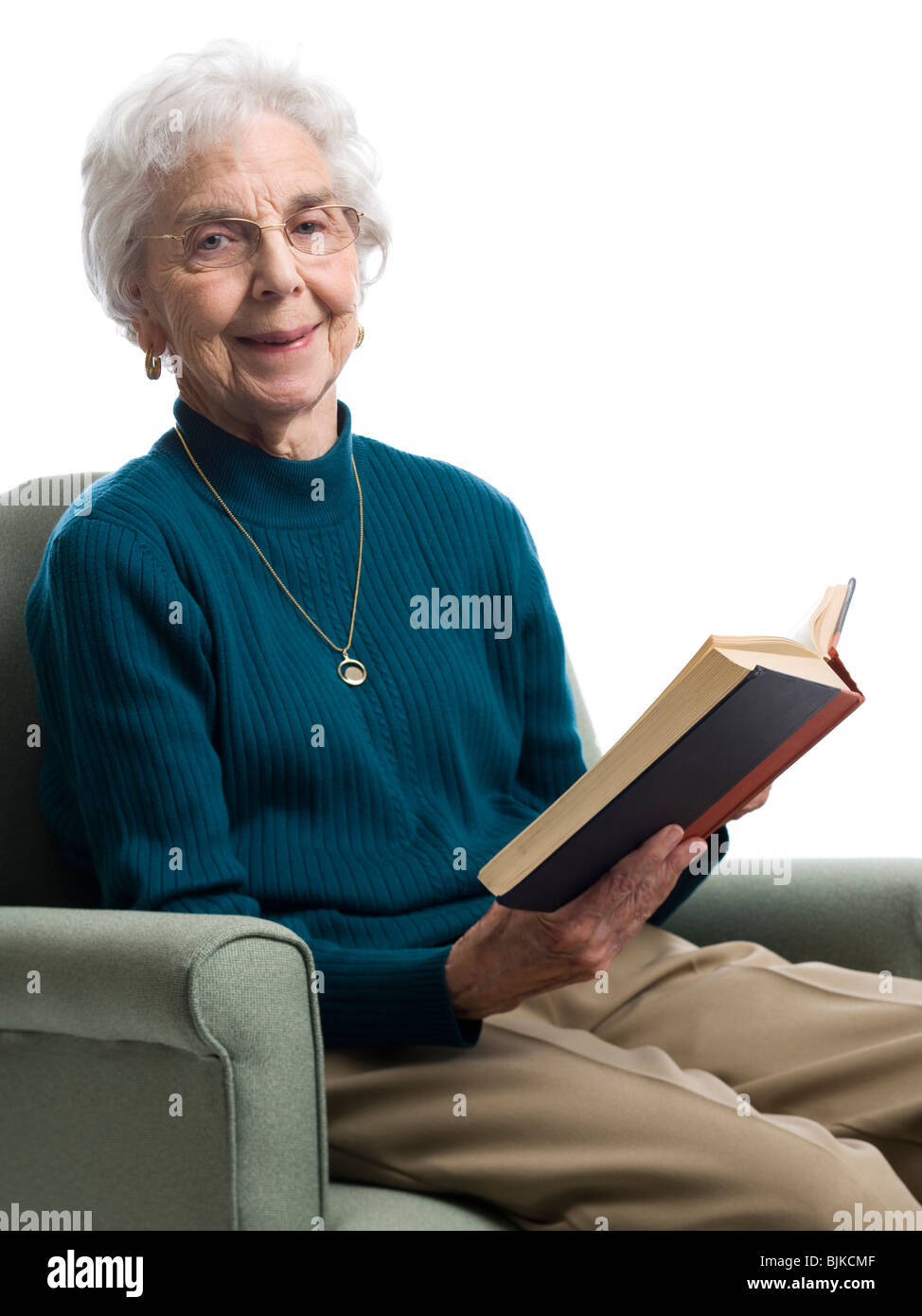 Elderly woman sitting in an armchair smiling Stock Photo - Alamy