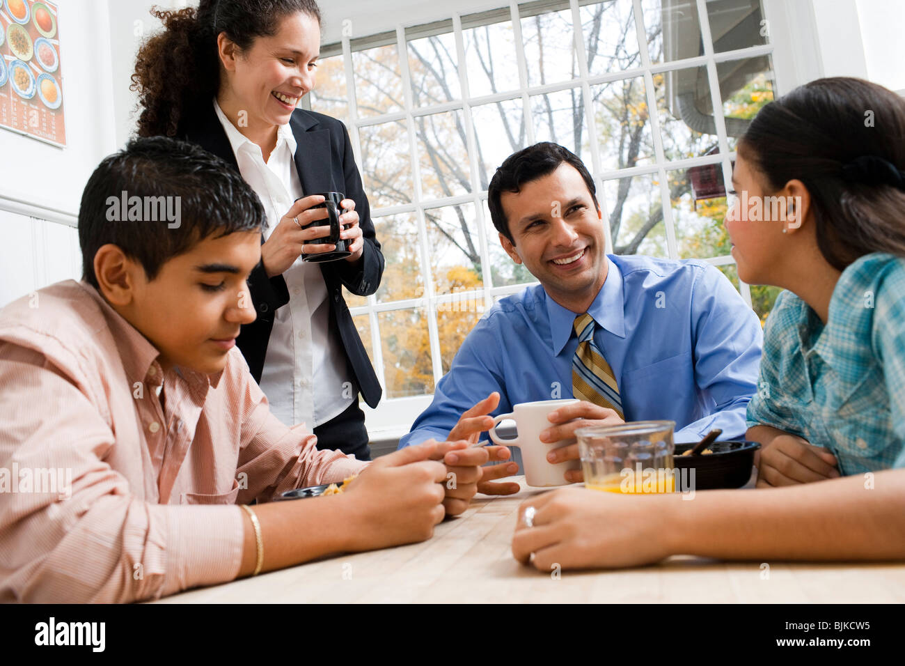 Family at breakfast table smiling Stock Photo - Alamy