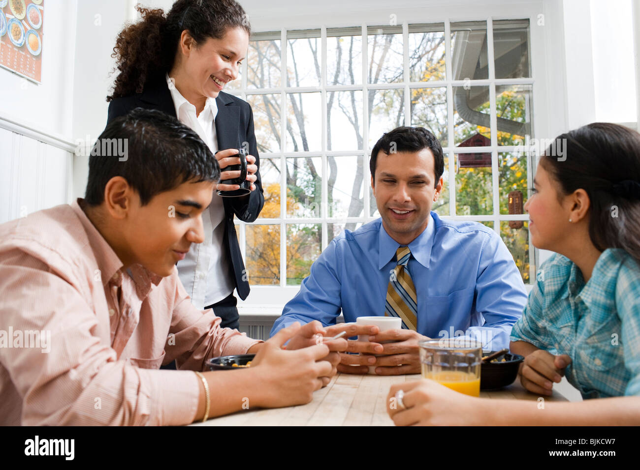 Family at breakfast table smiling Stock Photo - Alamy