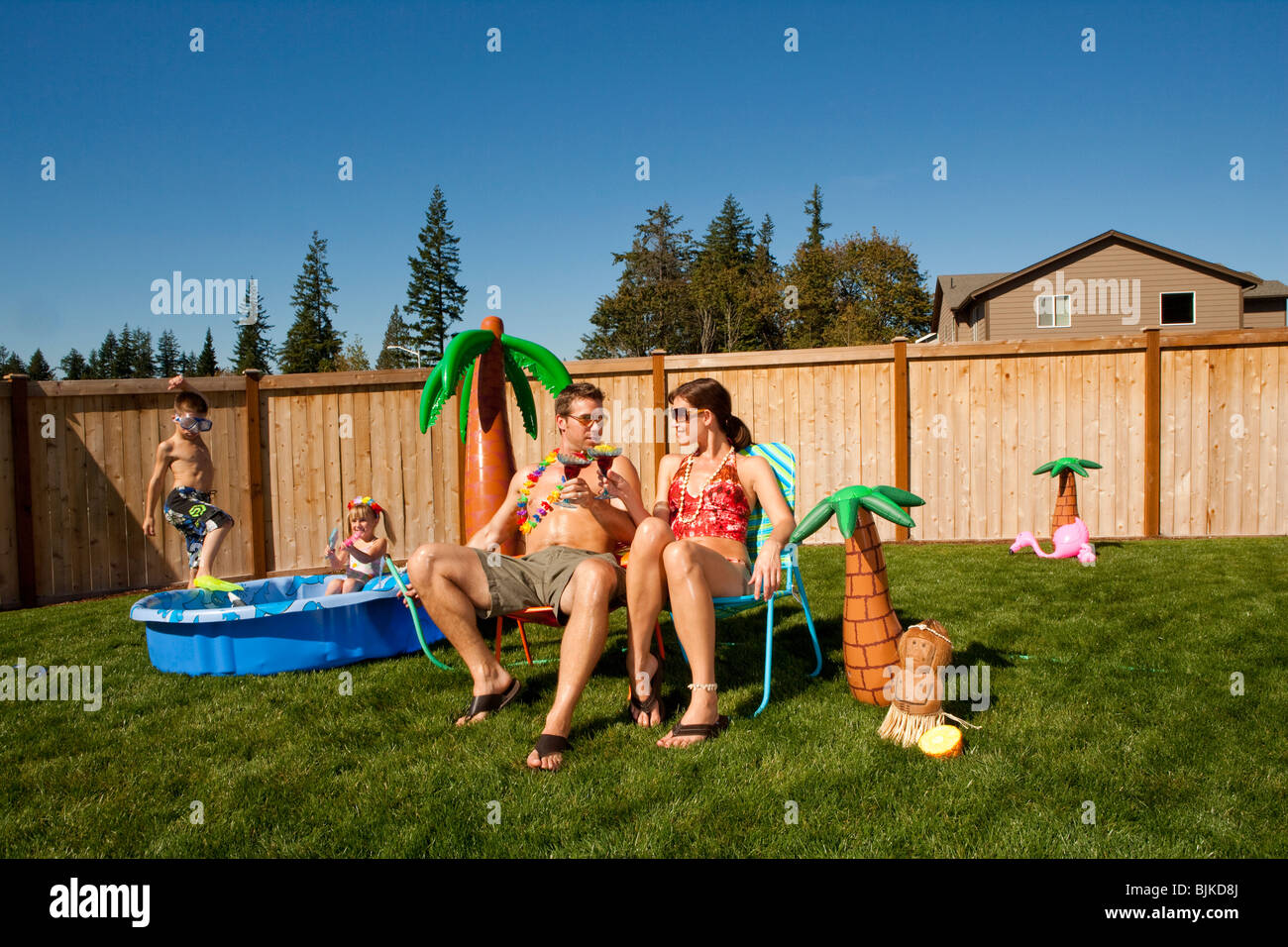 Family in yard with children's pool and cocktails Stock Photo