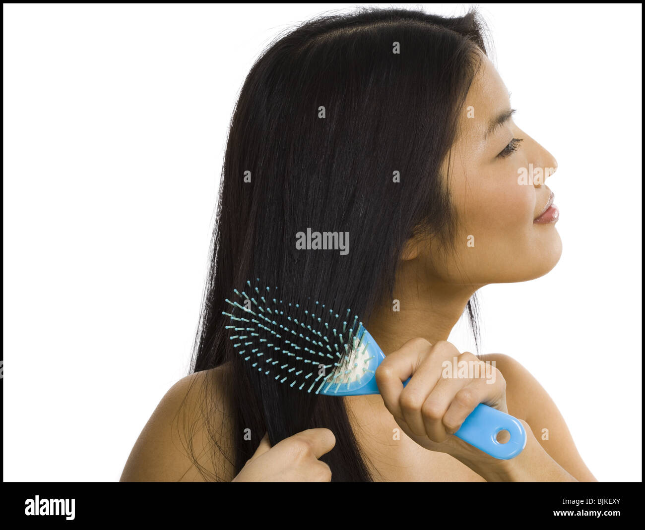 Smiling woman brushing hair Stock Photo