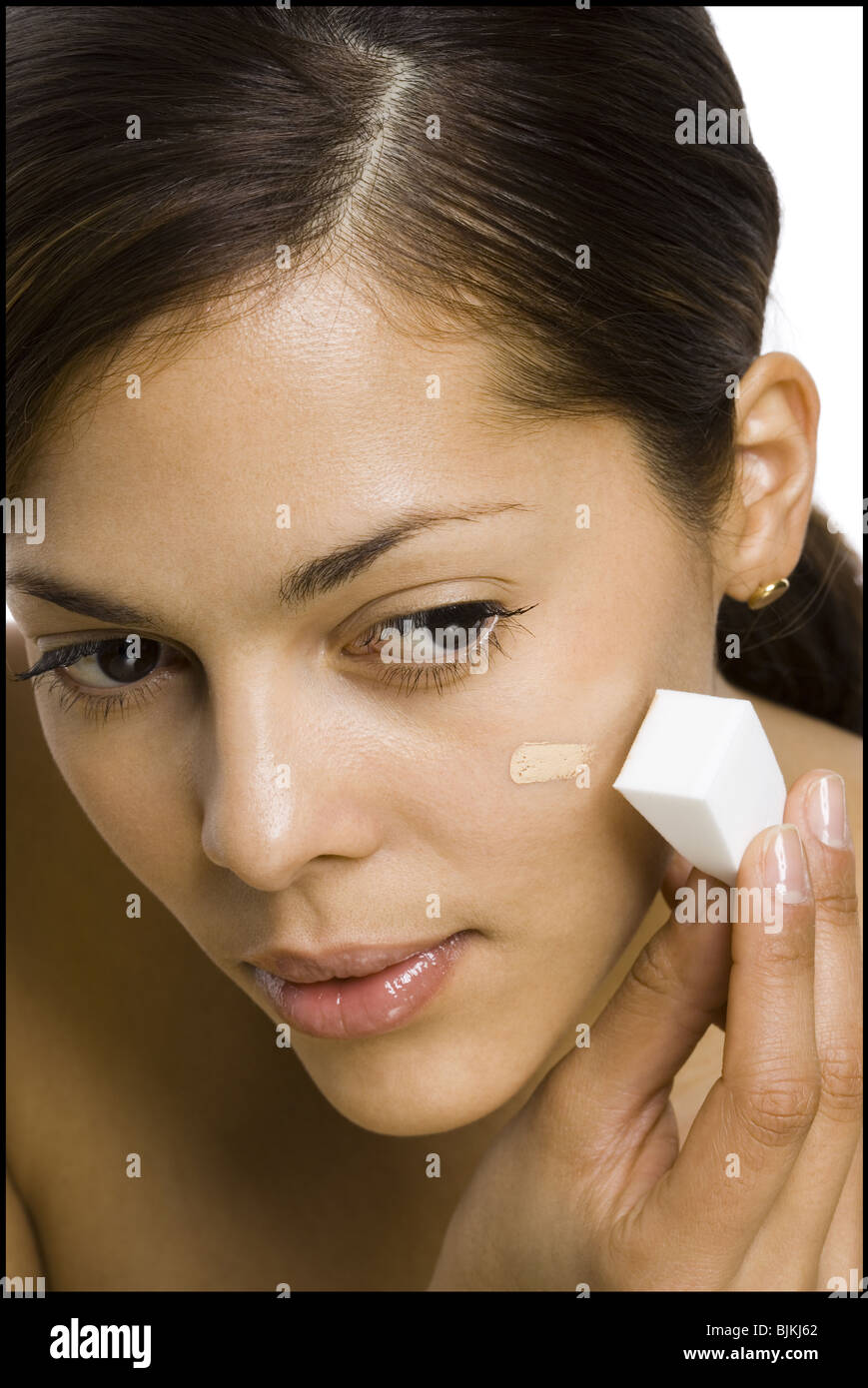 Woman applying foundation with makeup sponge Stock Photo Alamy