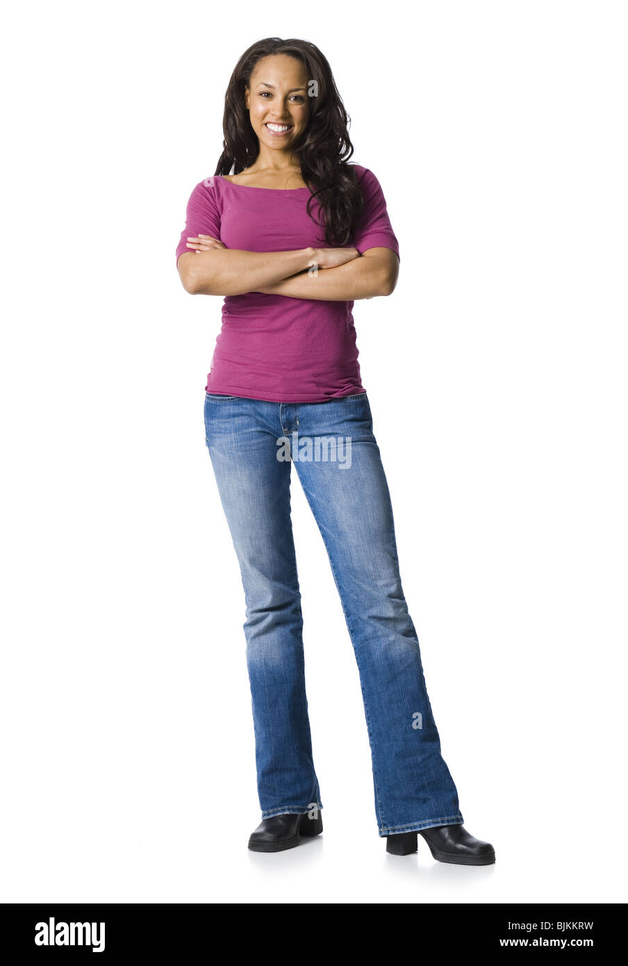 Woman in blue jeans standing with arms crossed Stock Photo