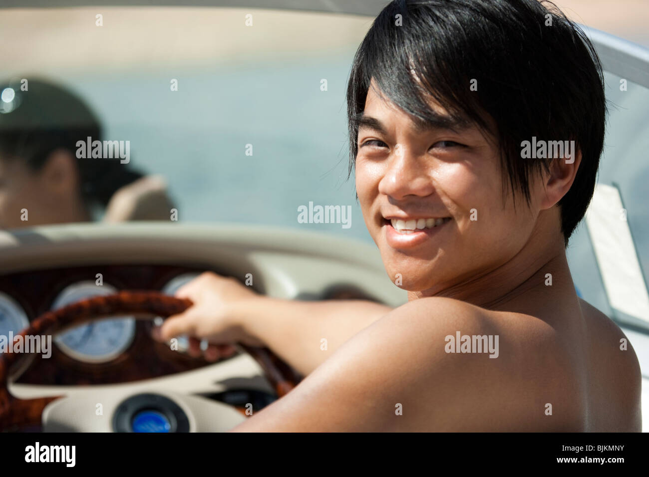 Man steering boat smiling Stock Photo - Alamy