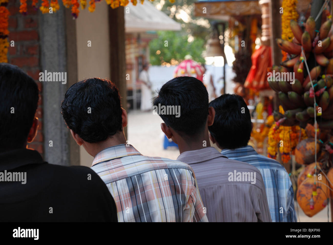 Young men looking into a Hindu temple, temple festival in Pulinkudi, Kerala state, India, Asia Stock Photo