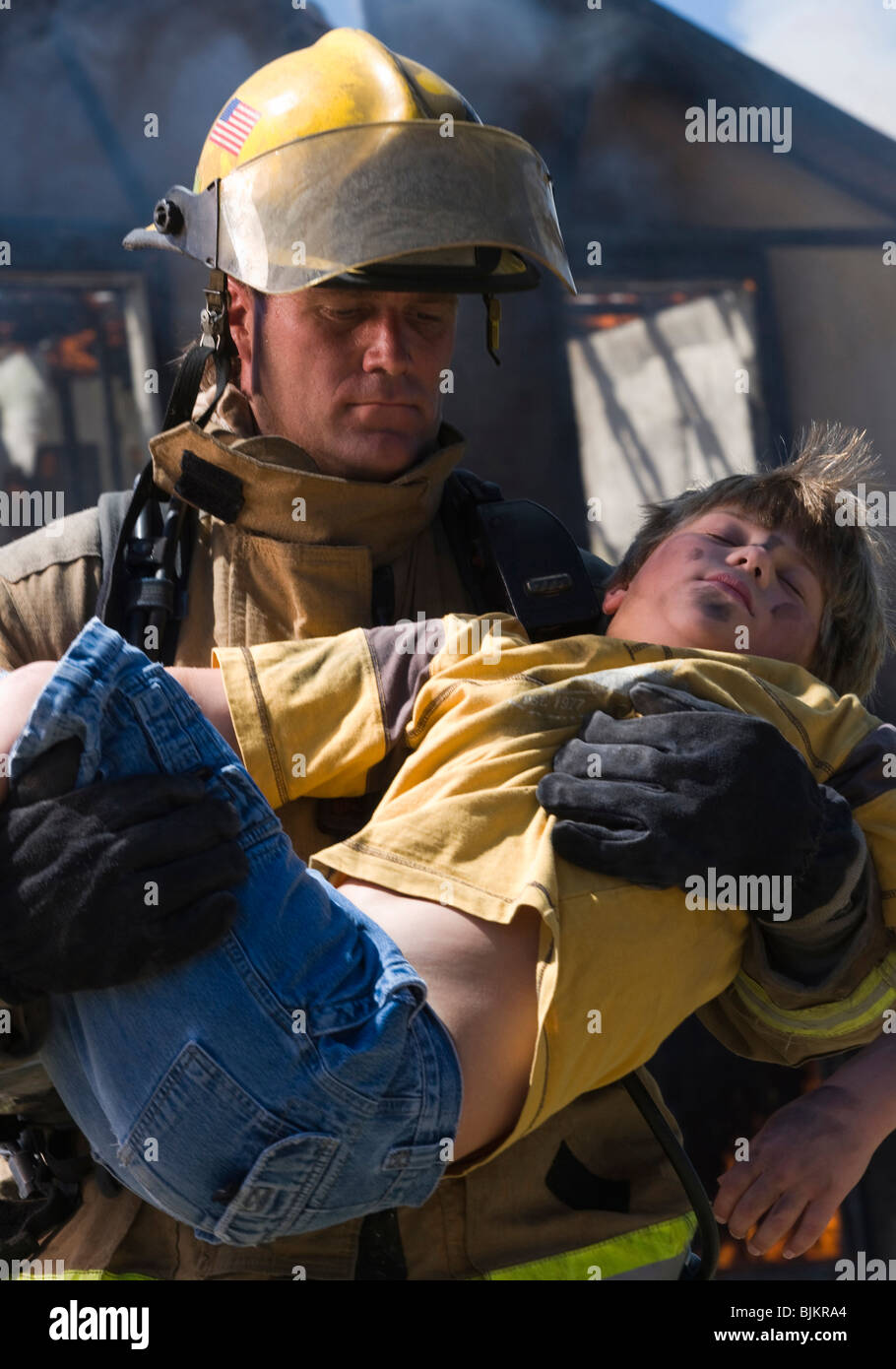 Fire fighter rescuing child Stock Photo