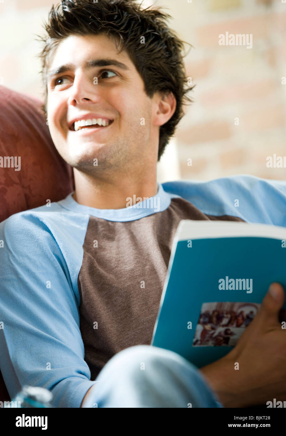 Man on sofa reading Stock Photo