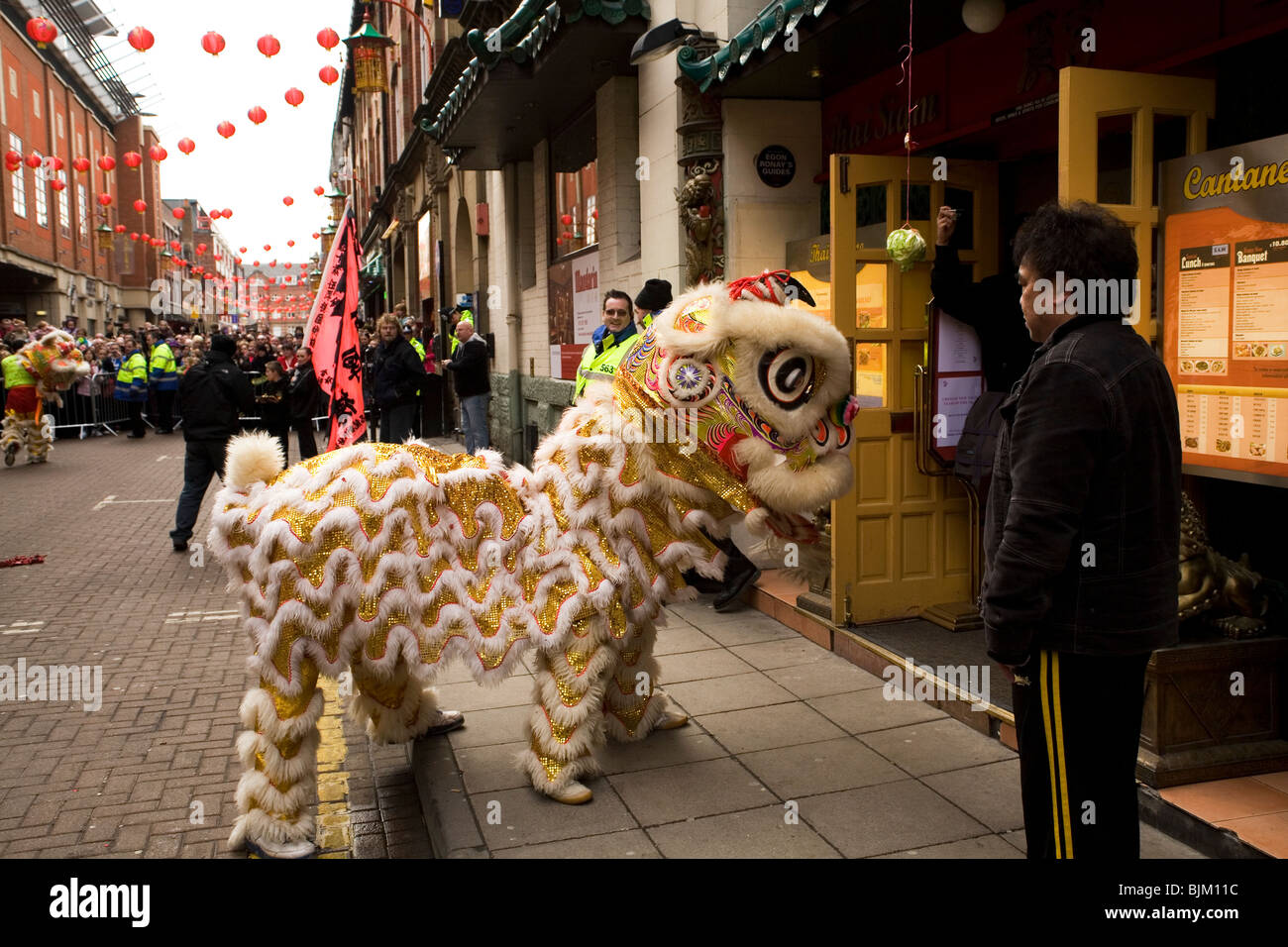 A dragon dances outside of restaurants as part of Chinese New Year celebrations in Chinatown at Newcastle-upon-Tyne, England. Stock Photo