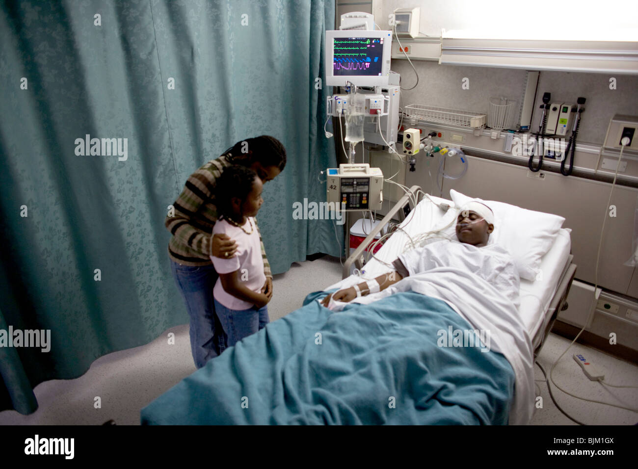 Parents with boy in hospital bed wearing head bandages Stock Photo Alamy