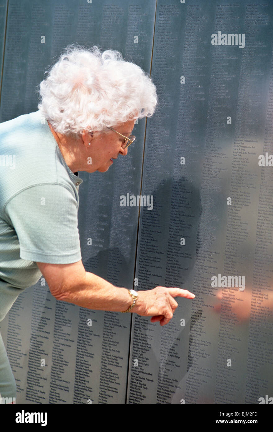 Senior Woman at the Immigrant Wall of Honor, Ellis Island, NYC Stock Photo