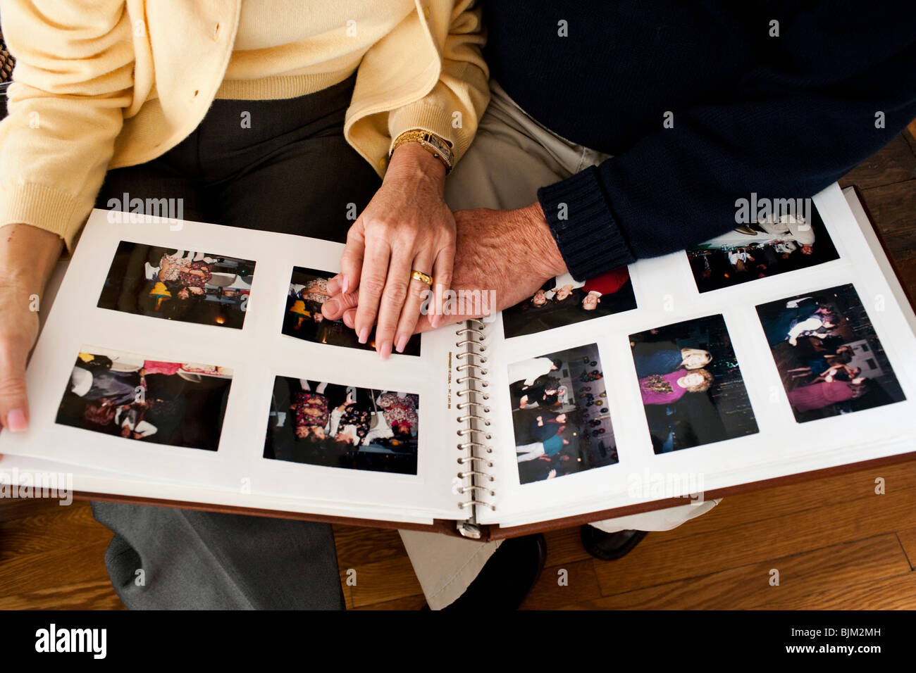 Mature hands on photo album Stock Photo - Alamy