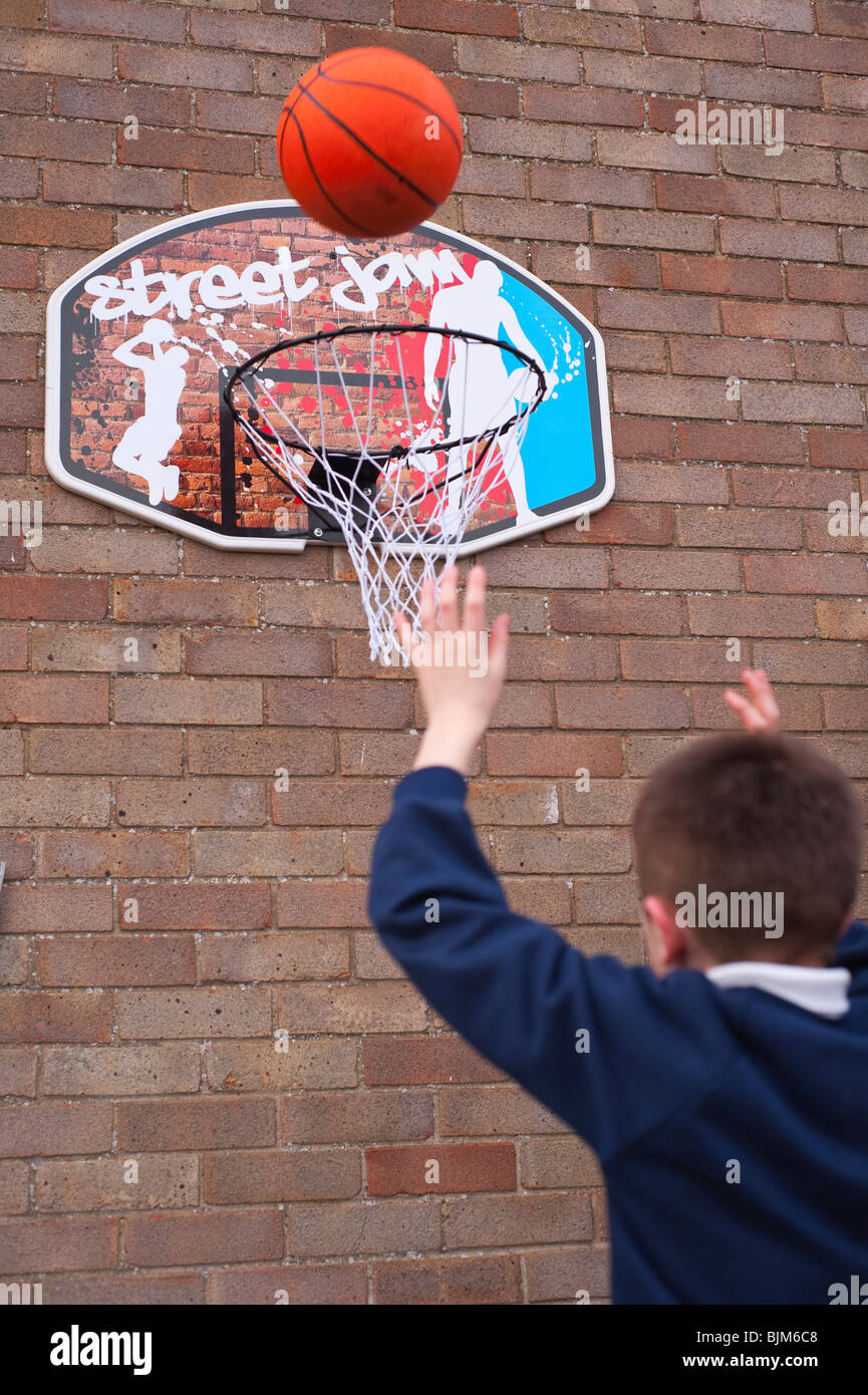 A MODEL RELEASED picture of a 10 year old boy playing basketball in the Uk Stock Photo