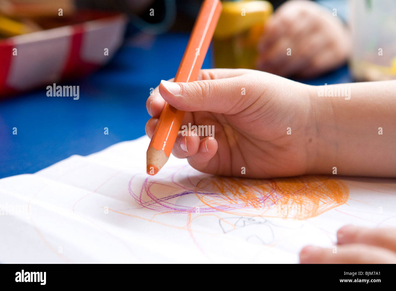 Hand holding a pencil, a child in kindergarten, drawing Stock Photo