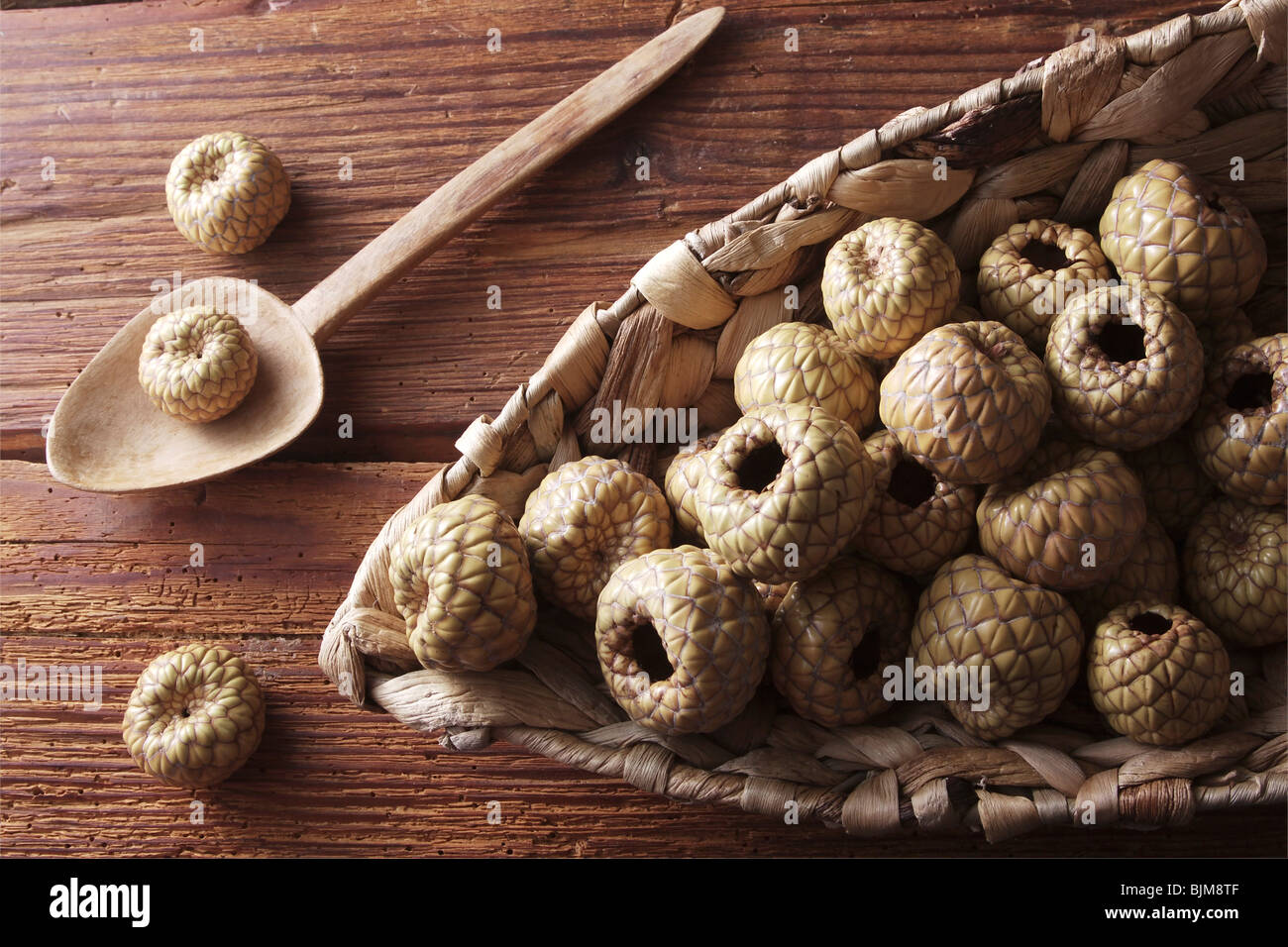 Salak or Snake Fruit (Salacca zalacca) in a wicker basket on a rustic wooden background Stock Photo