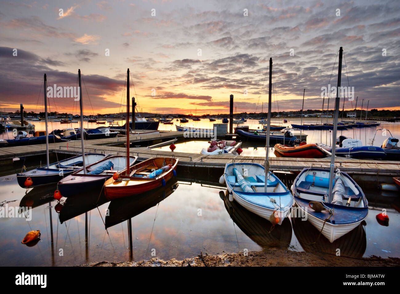 Sun setting over boats moored at Bembridge Harbour. Isle of Wight, England, UK Stock Photo