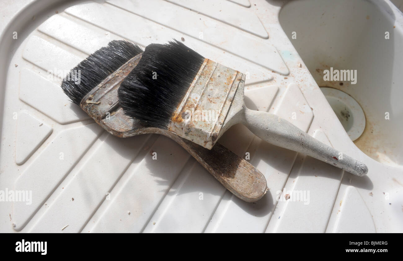 A PAIR OF PAINT BRUSHES ON A SINK UNIT,UK Stock Photo