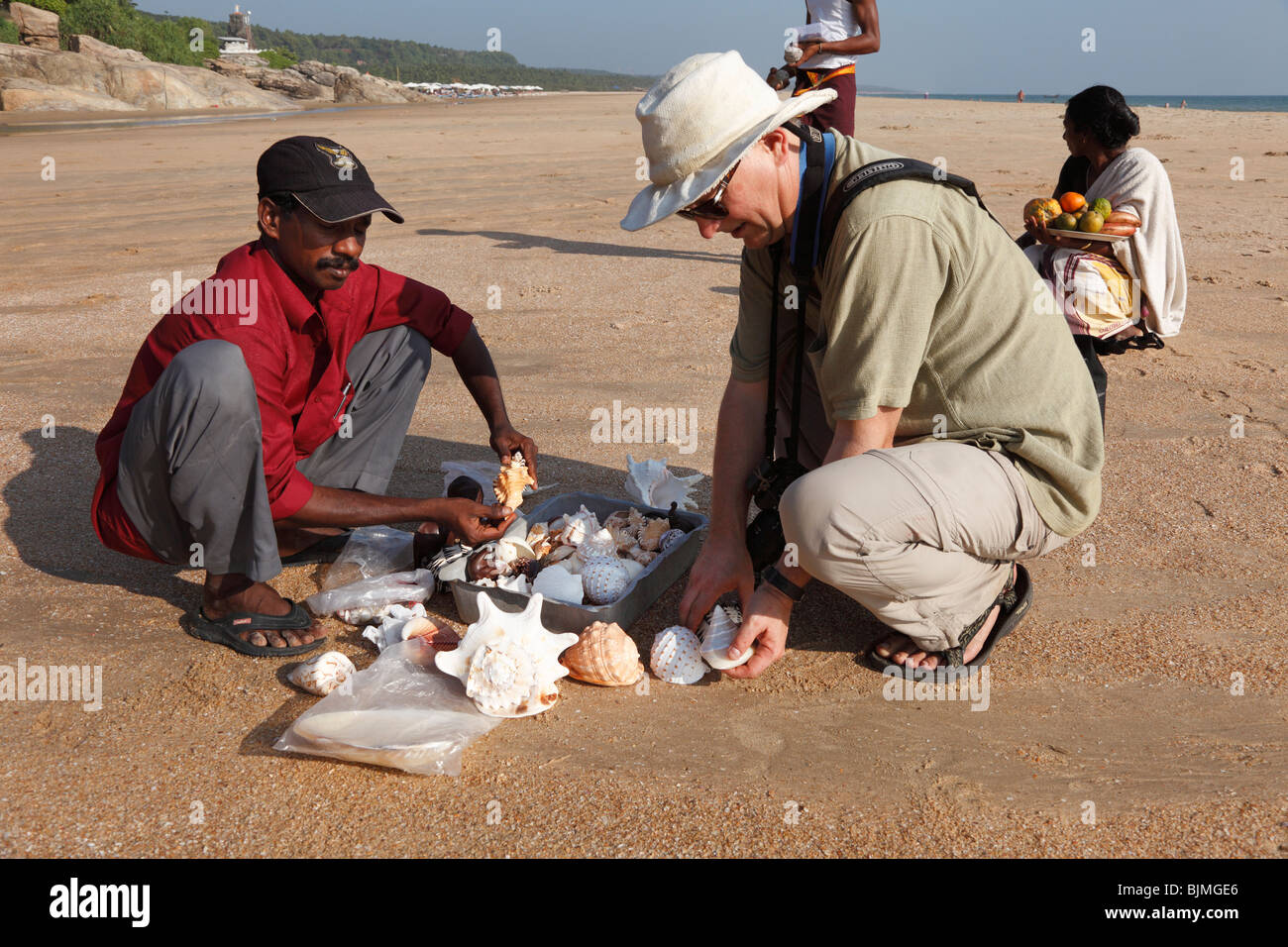 Tourist buying seashells on the beach, Somatheeram Beach, Malabarian Coast, Malabar, Kerala state, India, Asia Stock Photo