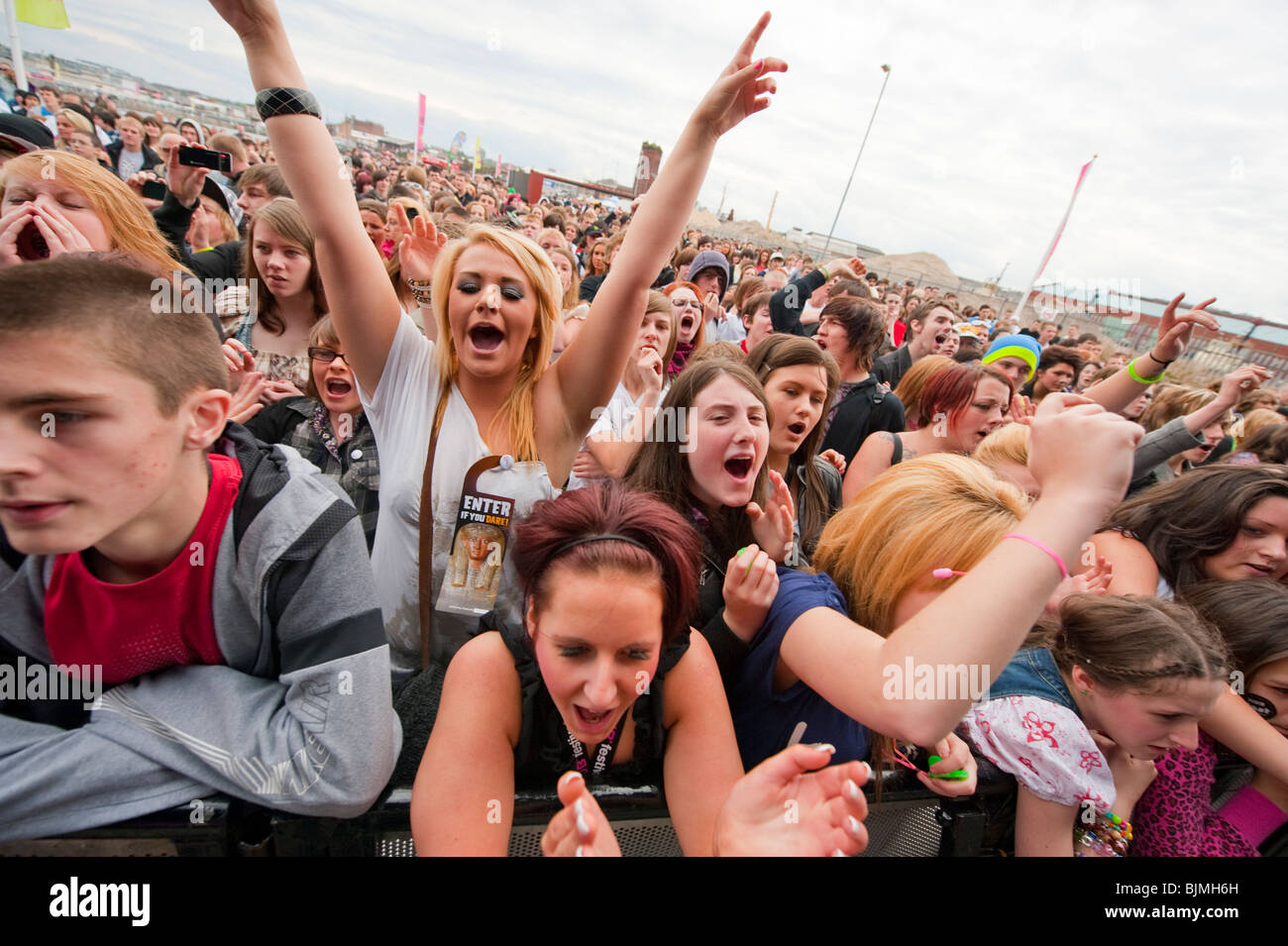 Teenage fans crowd watch pop star on stage Stock Photo