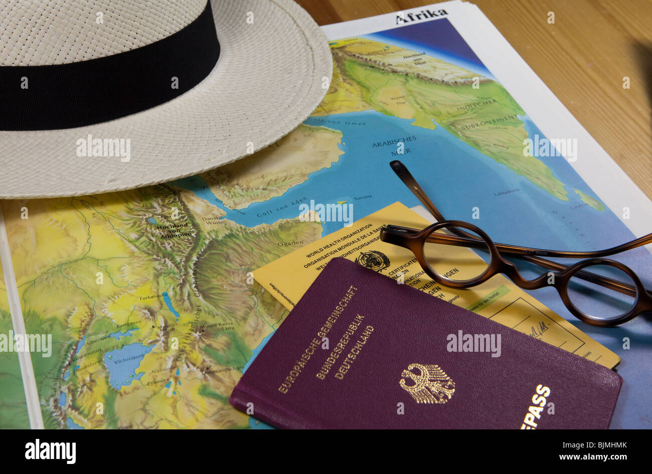 Planning a trip to Africa, historical reading glasses, passport and vaccination record Stock Photo