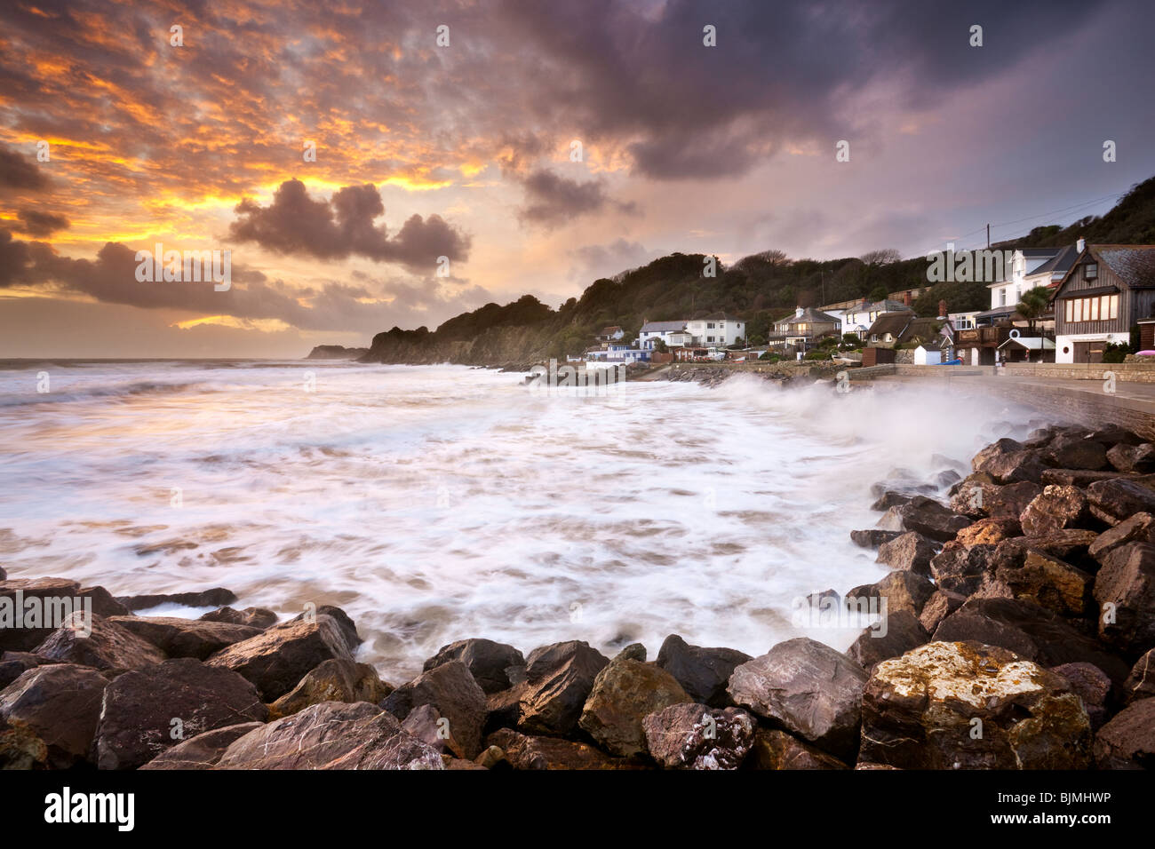Sun setting over waves crashing on rocks at Steephill Cove. Isle of Wight, England, UK Stock Photo