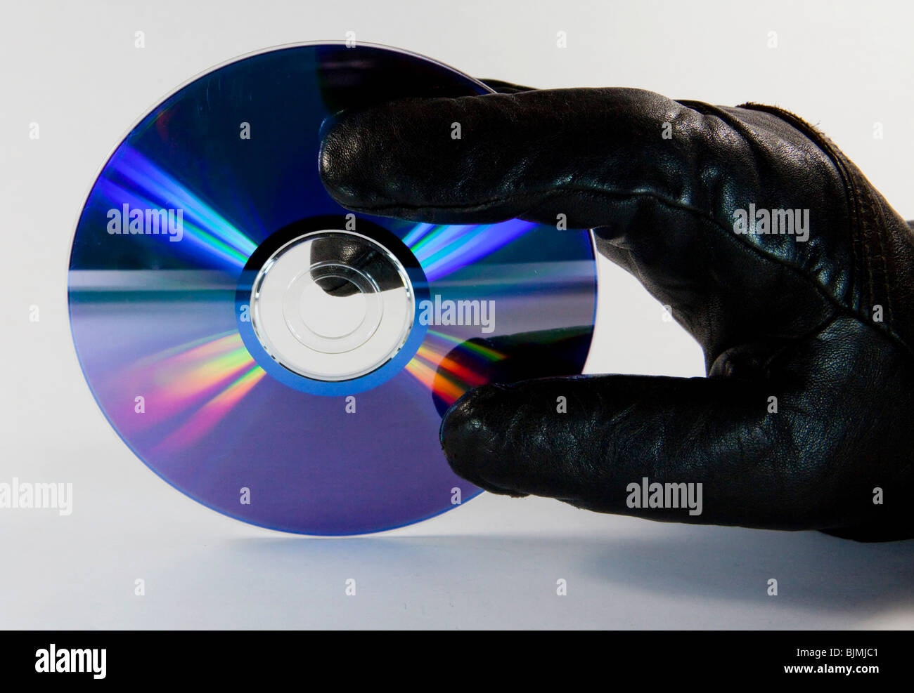Thief, fraudster, glove, trying to steal a CD, DVD Stock Photo