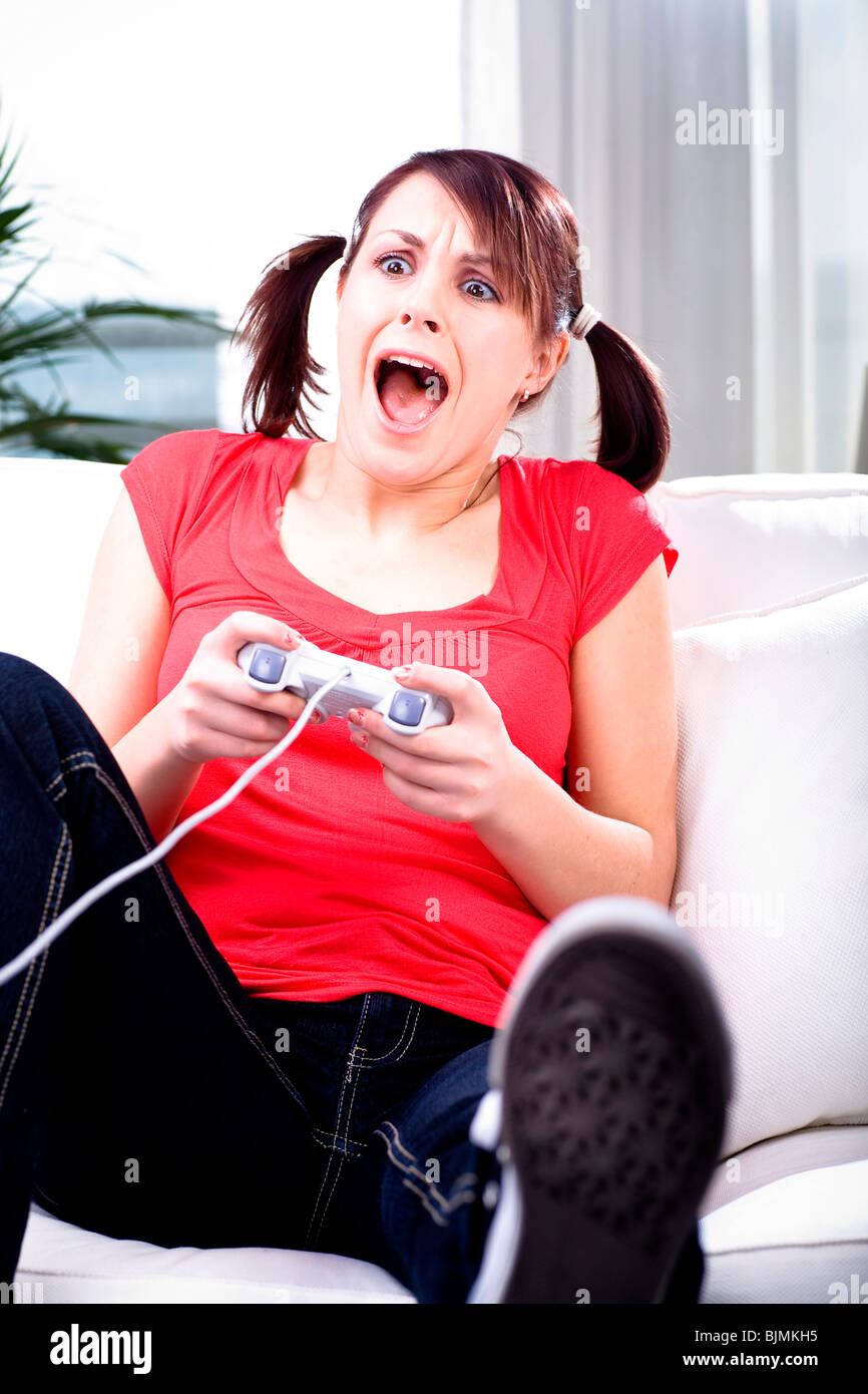 19-year-old girl playing on a game console Stock Photo