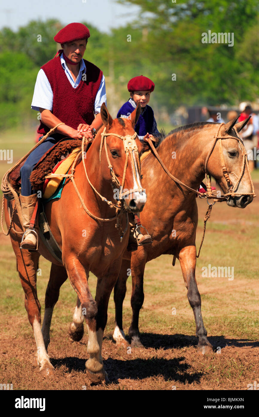Paisano (modern gaucho) and kid with horses at San Antonio de Areco Gaucho Festival. Fiesta de la Tradicion/ Tradition party Stock Photo